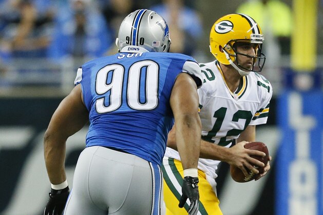 Detroit Lions defensive tackle Ndamukong Suh (90) chases Green Bay Packers quarterback Aaron Rodgers (12) during the first half of an NFL football game in Detroit, Sunday, Sept. 21, 2014. (AP Photo/Rick Osentoski)