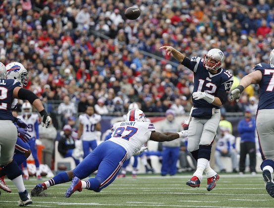 New England Patriots quarterback Tom Brady (12) passes over Buffalo Bills defensive tackle Corbin Bryant (97) in the first half of an NFL football game Sunday, Dec. 28, 2014, in Foxborough, Mass. (AP Photo/Elise Amendola)