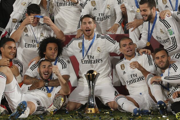 Real Madrid’s Sergio Ramos, centre, who scored the team's first goal, poses alongside team mates with the trophy after winning the final soccer match between Real Madrid and San Lorenzo at the Club World Cup soccer tournament in Marrakech, Morocco, Saturday, Dec. 20, 2014. (AP Photo/Christophe Ena)