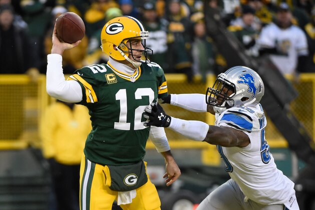 Dec 28, 2014; Green Bay, WI, USA;  Green Bay Packers quarterback Aaron Rodgers (12) gets a pass away from Detroit Lions linebacker Tahir Whitehead (59) in the second quarter at Lambeau Field. Mandatory Credit: Benny Sieu-USA TODAY Sports