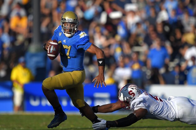 UCLA quarterback Brett Hundley, left, escapes a tackle by Stanford linebacker James Vaughters during the second half of an NCAA college football game, Friday, Nov. 28, 2014, in Pasadena, Calif. Stanford won 31-10. (AP Photo/Mark J. Terrill)