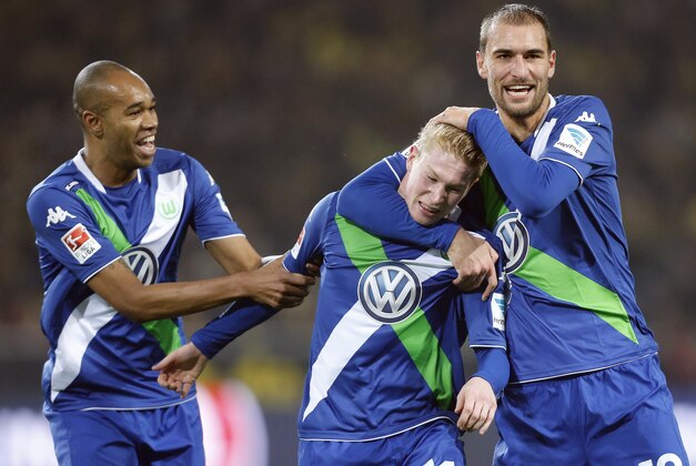 From left, Wolfburg's Naldo, Kevin De Bruyne and Bas Dost celebrate after scoring during the German first division Bundesliga soccer match between Borussia Dortmund and VfL Wolfsburg in Dortmund, Germany, Wednesday, Dec. 17, 2014. (AP Photo/Frank Augstein)