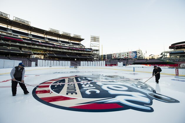 WASHINGTON, DC - DECEMBER 27:  Members of the ice crew install the center ice logo on the ice during the 2015 Bridgestone NHL Winter Classic Build Out on December 27, 2014 at Nationals Park in Washington, DC. The 2015 Bridgestone NHL Winter Classic will take place on New Year's Day with the Washington Capitals playing the Chicago Blackhawks.  (Photo by Patrick McDermott/NHLI via Getty Images)