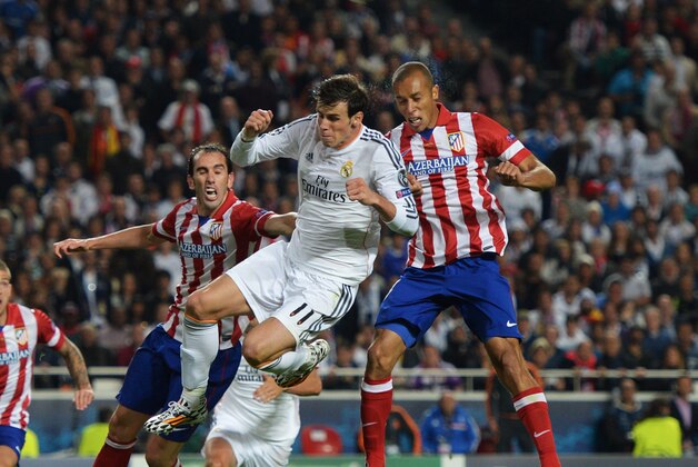 LISBON, PORTUGAL - MAY 24:  Gareth Bale of Real Madrid jumps with Miranda (R) and Diego Godin of Club Atletico de Madrid (3R) during the UEFA Champions League Final between Real Madrid and Atletico de Madrid at Estadio da Luz on May 24, 2014 in Lisbon, Portugal.  (Photo by Michael Regan/Getty Images)