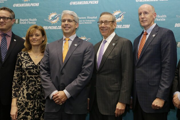 Dennis Hickey, new general manager for the Miami Dolphins football team, third from left, poses for a photo with team officials before being introduced at a news conference, Tuesday, Jan. 28, 2014, in Davie, Fla. Shown from left to right are CEO Tom Garfinkel, Executive Vice President for football operations Dawn Aponte, Hickey, owner Stephen Ross, head coach Joe Philbin, and vice chairman Matt Higgins. (AP Photo/Lynne Sladky)