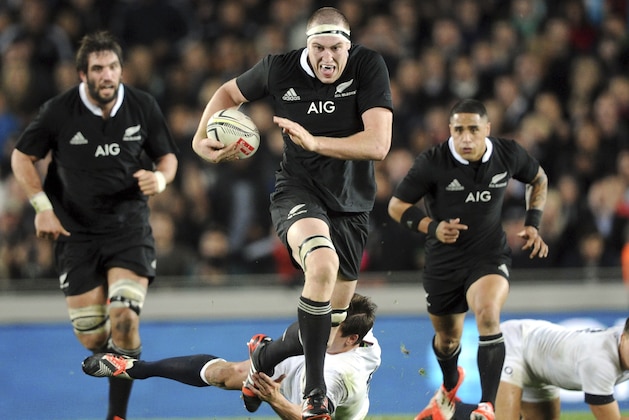 New Zealand’s Brodie Retallick, center, slips a tackle of England’s Freddie Burns in their international rugby test at Eden Park in Auckland, New Zealand, Saturday, June 7, 2014. (AP Photo/SNPA, Ross Setford)  NEW ZEALAND OUT