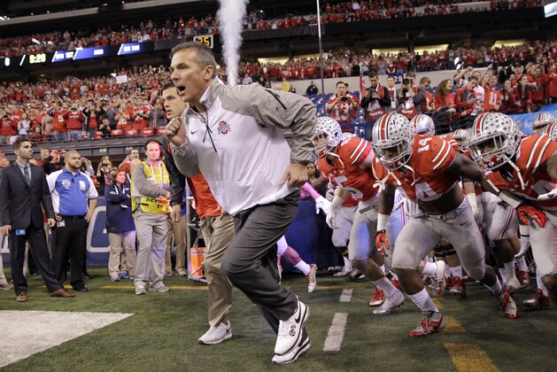 Ohio State head coach Urban Meyer runs onto the field with his team at the start of the Big Ten Conference championship NCAA college football game against Wisconsin Saturday, Dec. 6, 2014, in Indianapolis. (AP Photo/Darron Cummings)