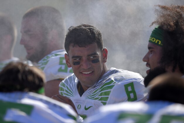 Oregon quarterback Marcus Mariota talks to teammates on the bench during the first half of a NCAA college football game against UCLA, Saturday, Oct. 11, 2014, in Pasadena, Calif. (AP Photo/Mark J. Terrill)