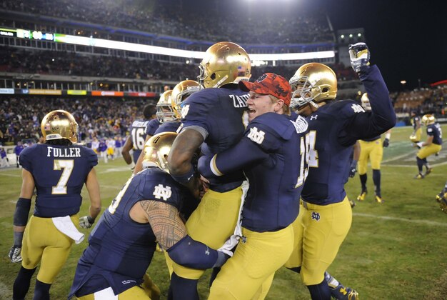 Dec 30, 2014; Nashville, TN, USA; Notre Dame Fighting Irish quarterback Malik Zaire (8) celebrates with teammates after winning against the LSU Tigers in the Music City Bowl at LP Field. Notre Dame won 31-28. Mandatory Credit: Christopher Hanewinckel-USA TODAY Sports