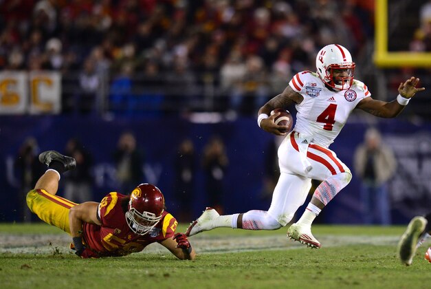 Dec 27, 2014; San Diego, CA, USA; Nebraska Cornhuskers quarterback Tommy Armstrong Jr. (4) carries the ball as USC Trojans linebacker J.R. Tavai (58) defends during the fourth quarter in the 2014 Holiday Bowl at Qualcomm Stadium. Mandatory Credit: Jake Roth-USA TODAY Sports
