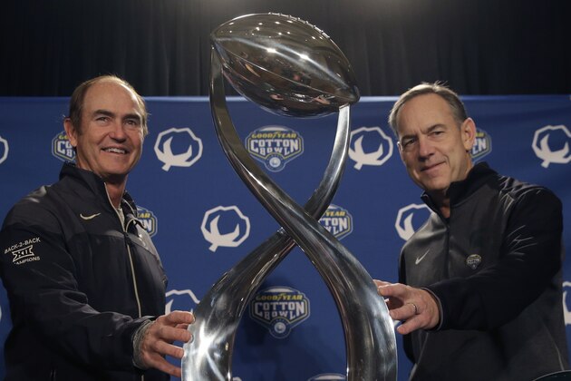 Baylor coach Art Briles, left, and Michigan State coach Mark Dantonio pose for photos with the Cotton Bowl trophy, Wednesday, Dec. 31, 2014, in Dallas. Baylor and Michigan State are scheduled to play in the Cotton Bowl on New Year's Day in Arlington, Texas. (AP Photo/LM Otero)