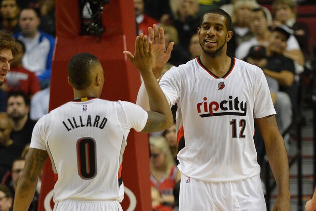 PORTLAND, OR - NOVEMBER 04: Damian Lillard #0 of the Portland Trail Blazers celebrates a basket by LaMarcus Aldridge #12 of the Portland Trail Blazers during the fourth quarter of the game against the Cleveland Cavaliers at Moda Center on November 4, 2014 in Portland, Oregon. NOTE TO USER: User expressly acknowledges and agrees that, by downloading and/or using this photograph, user is consenting to the terms and conditions of the Getty Images License Agreement. Mandatory copyright notice.  (Photo by Steve Dykes/Getty Images)