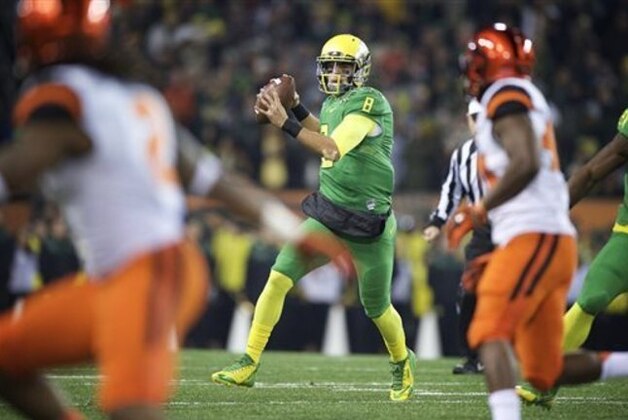 Oregon quarterback Marcus Mariota (8) throws a pass during the first quarter of an NCAA college football game against Oregon State in Corvallis, Or., Saturday, Nov. 29, 2014. (AP Photo/Troy Wayrynen)