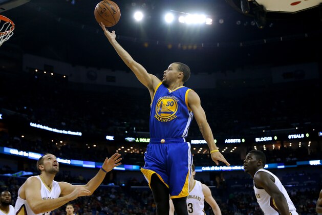 Golden State Warriors guard Stephen Curry (30) shoots over New Orleans Pelicans forward Ryan Anderson, left, and guard Jrue Holiday, right, during the first half of an NBA basketball game in New Orleans, Sunday, Dec. 14, 2014. (AP Photo/Jonathan Bachman)