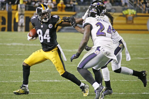 Pittsburgh Steelers wide receiver Antonio Brown (84) stiff arms Baltimore Ravens cornerback Lardarius Webb (21) after catching a pass from quarterback Ben Roethlisberger during the second half of an NFL football game against the Baltimore Ravens Sunday, Nov. 2, 2014, in Pittsburgh. (AP Photo/Gene Puskar)