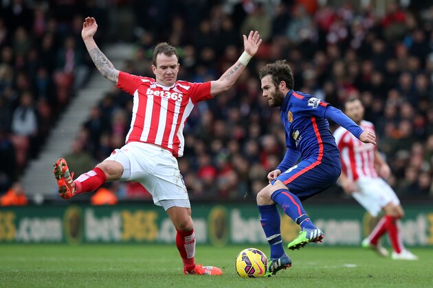 STOKE ON TRENT, ENGLAND - JANUARY 01:  Juan Mata of Manchester United competes with Glenn Whelan of Stoke City during the Barclays Premier League match between Stoke City and Manchester United at Britannia Stadium on January 1, 2015 in Stoke on Trent, England.  (Photo by Jan Kruger/Getty Images)