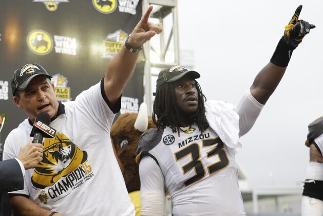 Missouri head coach Gary Pinkel, left, and defensive lineman Markus Golden (33) point to cheering fans after winning the Citrus Bowl NCAA college football game against Minnesota 33-17 in Orlando, Fla., Thursday, Jan. 1, 2015. (AP Photo/John Raoux)