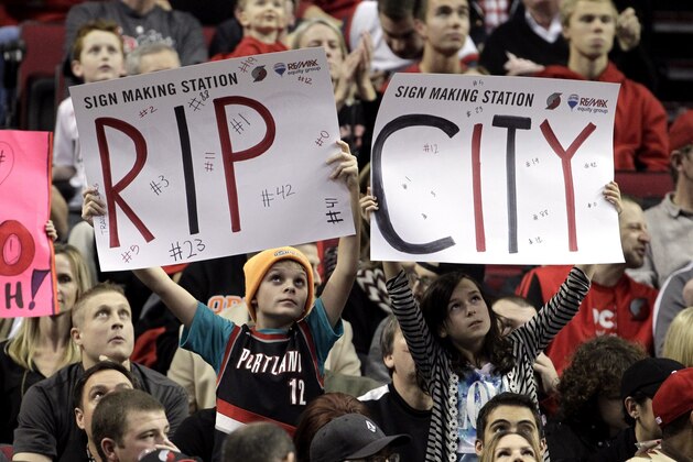 Portland Trail Blazers fans hold signs during the first half of an NBA basketball game against the Toronto Raptors in Portland, Ore., Tuesday, Dec. 30, 2014. (AP Photo/Don Ryan)