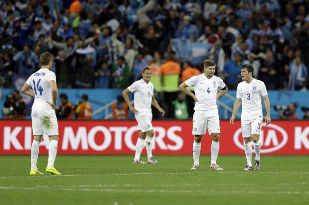 England players stand on the pitch following Uruguay's Luis Suarez's second goal during the group D World Cup soccer match between Uruguay and England at the Itaquerao Stadium in Sao Paulo, Brazil, Thursday, June 19, 2014. (AP Photo/Kirsty Wigglesworth)