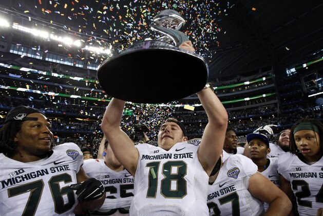Jan 1, 2015; Arlington, TX, USA; Michigan State Spartans quarterback Connor Cook (18) holds up the Cotton Bowl trophy after the game against the Michigan State Spartans in the 2015 Cotton Bowl Classic at AT&T Stadium. Michigan State beat Baylor 42-41. Mandatory Credit: Tim Heitman-USA TODAY Sports