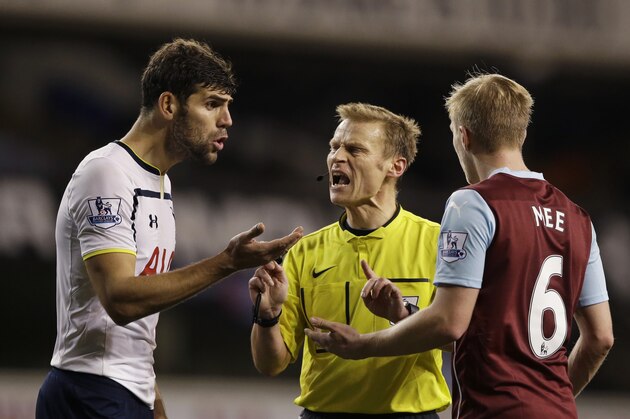 Referee Mike Jones, center, speaks to Tottenham Hotspur's Federico Fazio, left, and Burnley's Ben Mee during the English Premier League soccer match between Tottenham Hotspur and Burnley at White Hart Lane stadium in London, Saturday, Dec. 20, 2014.  (AP Photo/Matt Dunham)