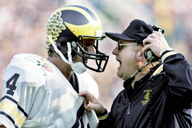 FILE - In this Jan. 2, 1987, file photo, Michigan head coach Bo Schembechler yells at quarterback Jim Harbaugh as the Wolverines fell victim to Arizona State 22-15 in the Rose Bowl NCAA college football game in Pasadena, Calif. The former Wolverines quarterback is returning to Ann Arbor, to coach his alma mater. The 51-year-old Harbaugh signed a seven-year deal to become the new coach at Michigan that will pay him $5 million per year. (AP Photo/Reed Saxon, File)