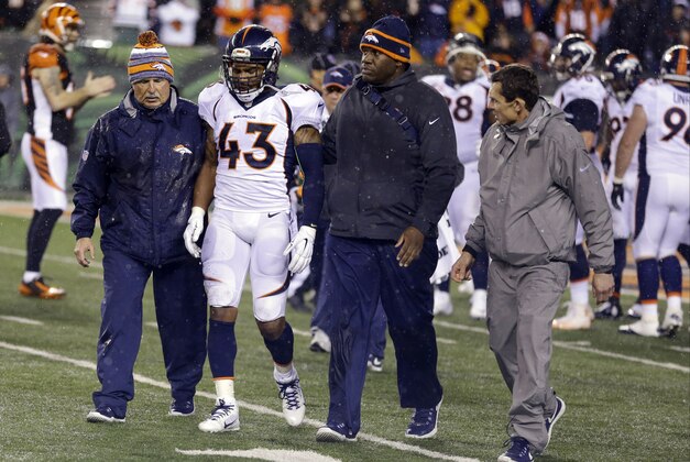 Denver Broncos strong safety T.J. Ward (43) is helped off the field after an injury during the second half of an NFL football game against the Cincinnati Bengals Monday, Dec. 22, 2014, in Cincinnati. (AP Photo/Michael Conroy)