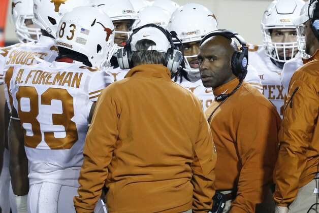 Texas head coach Charlie Strong, right, stands with his team during a time out in the fourth quarter of an NCAA college football game against Oklahoma State in Stillwater, Okla., Saturday, Nov. 15, 2014. Texas won 28-7. (AP Photo/Sue Ogrocki)