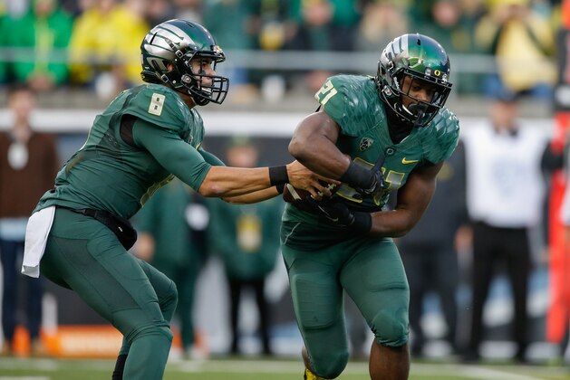 EUGENE, OR - NOVEMBER 22:  Quarterback Marcus Mariota #8 of the Oregon Ducks fakes a handoff to running back Royce Freeman #21 against the Colorado Buffaloes at Autzen Stadium on November 22, 2014 in Eugene, Oregon. Mariota was removed from the game after the play, making it his last as an Oregon Duck at home during the regular season.  (Photo by Otto Greule Jr/Getty Images)