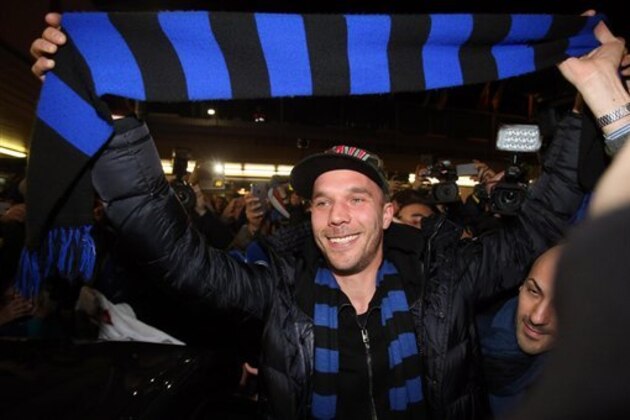 German forward Lukas Podolski holds up an Inter Milan scarf as he arrives at the Linate airport, Milan, Italy, Friday, Jan. 2, 2015. Podolski is joining the Serie A club Inter Milan. (AP Photo/Ansa/Matteo Bazzi)