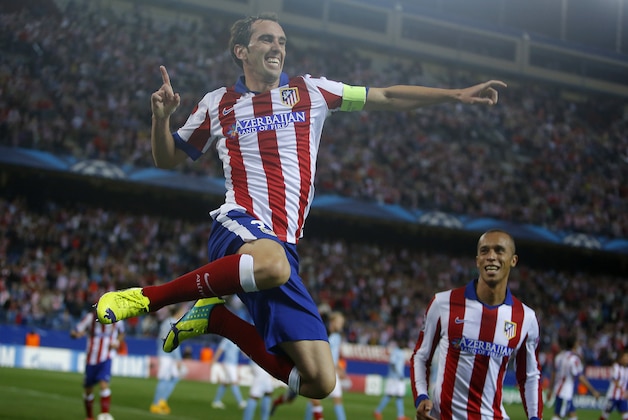 Atletico's Diego Godin, right, celebrates with his teammate Miranda after scoring during the Group A Champions League soccer match between Atletico de Madrid and Malmo at the Vicente Calderon stadium in Madrid, Spain, Wednesday, Oct. 22, 2014. (AP Photo/Andres Kudacki)
