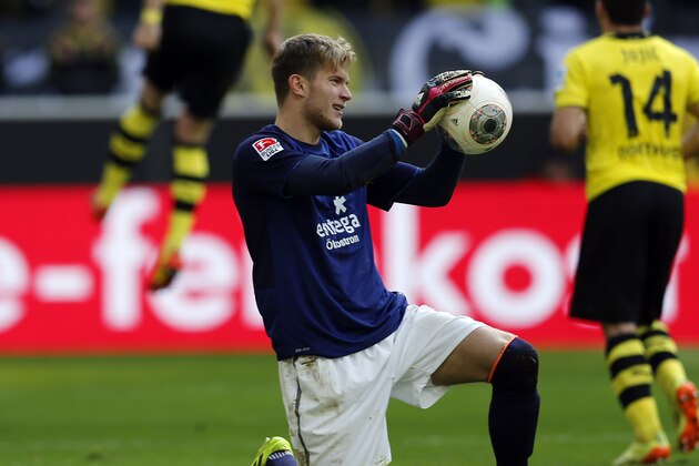 Mainz goalkeeper Loris Karius, center, holds the ball while Dortmund's Marco Reus, left, celebrates after scoring during the German first division Bundesliga soccer match between BvB Borussia Dortmund and Mainz 05 in Dortmund, Germany, Saturday, April 19, 2014. (AP Photo/Frank Augstein)