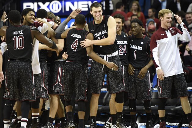 South Carolina's guard Duane Notice (10), guard Tyrone Johnson (4), forward Laimonas Chatkevicius (14), forward Michael Carrera (24) and guard Marcus Stroman (1) celebrate their 64-60 win over Iowa State in an NCAA college basketball game at Barclays Center on Saturday, Jan. 3, 2015 in New York. (AP Photo/Kathy Kmonicek)