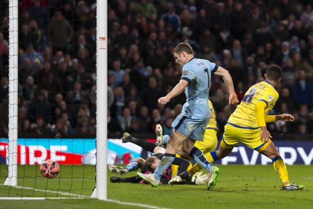 Manchester City's James Milner, centre, scores his second goal as his team beat Sheffield Wednesday 2-1 during their English FA Cup third round soccer match at the Etihad Stadium, Manchester, England, Sunday, Jan. 4, 2015. (AP Photo/Jon Super)