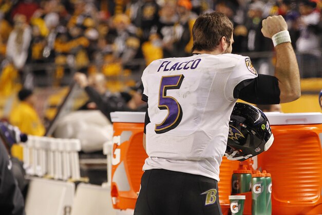 Jan 3, 2015; Pittsburgh, PA, USA; Baltimore Ravens quarterback Joe Flacco (5) celebrates on the bench in the final minute of the fourth quarter against the Pittsburgh Steelers in the 2014 AFC Wild Card playoff football game at Heinz Field. The Ravens won 30-17. Mandatory Credit: Geoff Burke-USA TODAY Sports
