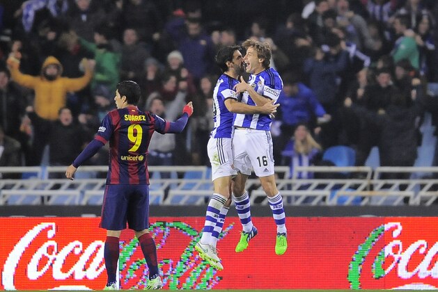 Real Sociedad's  Xabier Prieto, and Sergio Canales, right, celebrate a goal of their team beside Barcelona's Luis Suarez of Uruguay, during their La Liga soccer match, at Anoeta stadium in San Sebastian, northern Spain, Sunday, Jan. 4, 2015. (AP Photo/Alvaro Barrientos)