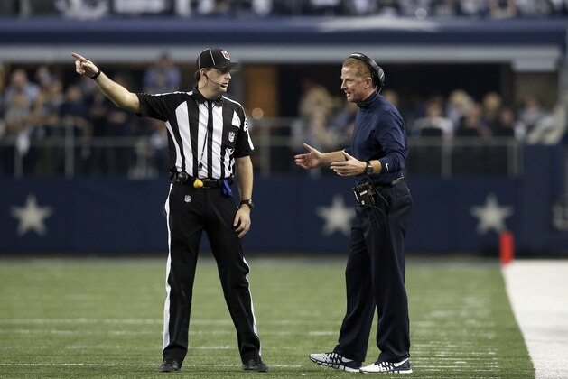 Dallas Cowboys head coach Jason Garrett argues a call with side judge Allen Baynes (56) during the second half of an NFL wildcard playoff football game against the Detroit Lions, Sunday, Jan. 4, 2015, in Arlington, Texas. (AP Photo/Brandon Wade)