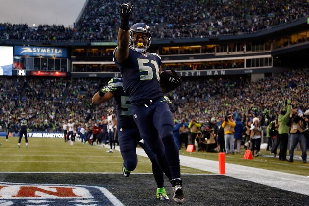 SEATTLE, WA - DECEMBER 28: Outside linebacker Bruce Irvin #51 of the Seattle Seahawks celebrates after running an interception back 49 yards for a touchdown during the fourth quarter of the game against the St. Louis Rams at CenturyLink Field on December 28, 2014 in Seattle, Washington. (Photo by Otto Greule Jr/Getty Images)