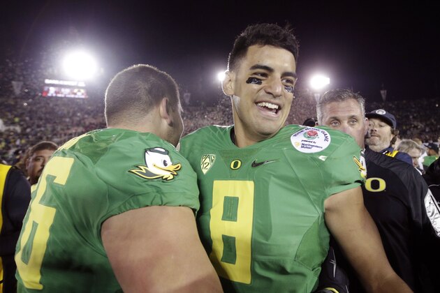 Oregon quarterback Marcus Mariota, right, celebrates with offensive lineman Jake Pisarcik after a 59-20 win against Florida State in the Rose Bowl NCAA college football playoff semifinal, Thursday, Jan. 1, 2015, in Pasadena, Calif. (AP Photo/Jae C. Hong)