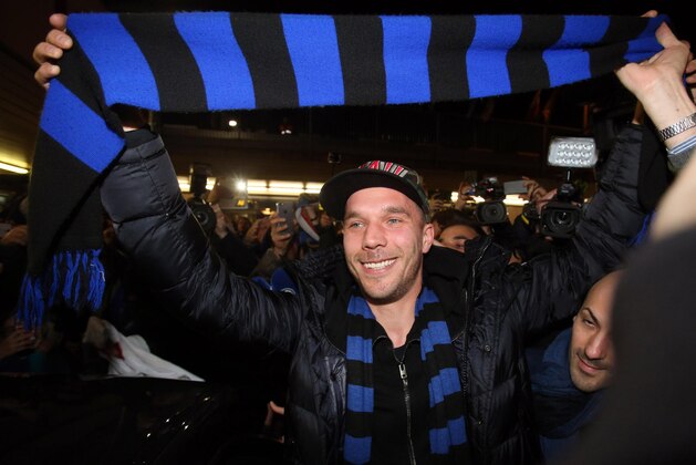 German forward Lukas Podolski holds up an Inter Milan scarf as he arrives at the Linate airport, Milan, Italy, Friday, Jan. 2, 2015. Podolski is joining the Serie A club Inter Milan. (AP Photo/Ansa/Matteo Bazzi)