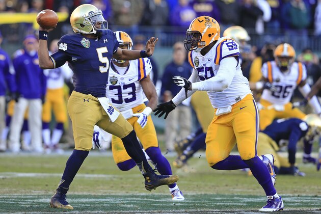 Notre Dame quarterback Everett Golson (5) gets a pass away as he is pressured by LSU defenders Jamal Adams (33) and Jermauria Rasco (59) in the first half of the Music City Bowl NCAA college football game, Tuesday, Dec. 30, 2014, in Nashville, Tenn. (AP Photo/Mark Humphrey)