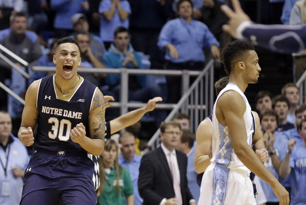 Notre Dame's Zach Auguste (30) celebrates as North Carolina's J.P. Tokoto walks away following Notre Dame's 71-70 win over North Carolina in an NCAA college basketball game in Chapel Hill, N.C., Monday, Jan. 5, 2015. (AP Photo/Gerry Broome)