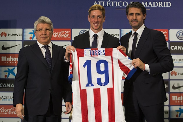 Spanish forward Fernando Torres, centre, holds his new Atletico de Madrid shirt with Sports Director Jose Luis Perez Caminero, right, and Atletico Madrid's President Enrique Cerezo, left, as they pose for photographers during his official presentation at the Vicente Calderon stadium in Madrid, Spain, Sunday, Jan. 4, 2015. (AP Photo/Andres Kudacki)