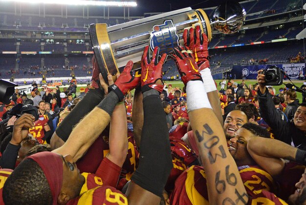 Dec 27, 2014; San Diego, CA, USA; The USC Trojans hold up the Holiday Bowl trophy after the game against the Nebraska Cornhuskers in the 2014 Holiday Bowl at Qualcomm Stadium. The Trojans beat the Cornhuskers 45-42. Mandatory Credit: Jake Roth-USA TODAY Sports