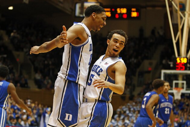 Duke's Jahlil Okafor (15) celebrates with teammate Tyus Jones (5) during the second half of an NCAA college basketball game against Presbyterian in Durham, N.C., Friday, Nov. 14, 2014. Okafor had 19 points and Jones added 15 in Duke's 113-44 win. (AP Photo/Karl B DeBlaker)