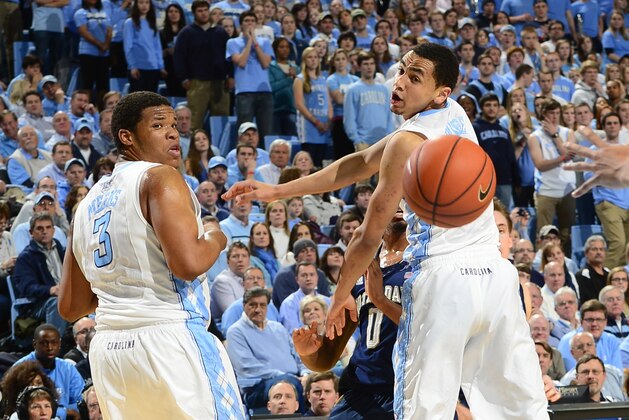 Mar 3, 2014; Chapel Hill, NC, USA; Notre Dame Fighting Irish guard Eric Atkins (0) passes the ball as North Carolina Tar Heels forward Kennedy Meeks (3) and guard Marcus Paige (5) defend at Dean E. Smith Student Activities Center. Mandatory Credit: Bob Donnan-USA TODAY Sports