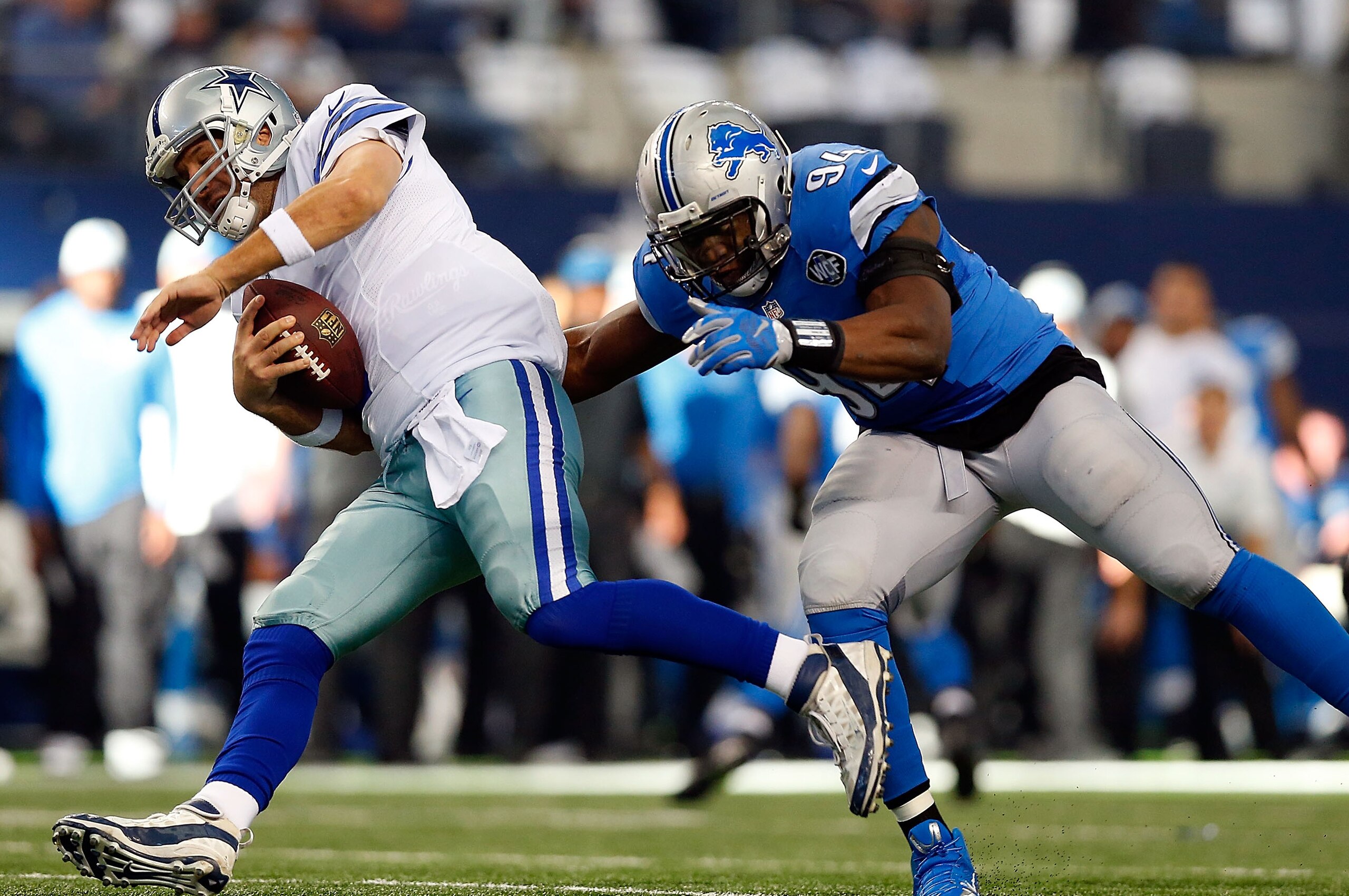 ARLINGTON, TX - JANUARY 04:  Tony Romo #9 of the Dallas Cowboys tries to escape the rush of Ezekiel Ansah #94 of the Detroit Lions during the first half of their NFC Wild Card Playoff game at AT&T Stadium on January 4, 2015 in Arlington, Texas.  (Photo by Tom Pennington/Getty Images)