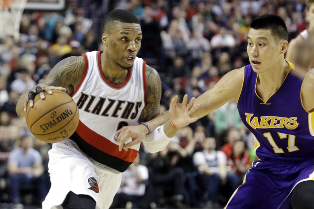 Portland Trail Blazers guard Damian Lillard, left, droves on Los Angeles Lakers guard Jeremy Lin during the second half of an NBA basketball game in Portland, Ore., Monday, Jan. 5, 2015.  Lillard led the Trail Blazers in scoring with 39 points, including four three-pointers, as they beat the Lakers 98-94. (AP Photo/Don Ryan)