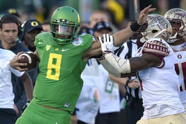 CORRECTS TO OREGON QUARTERBACK MARCUS MARIOTA NOT REGGIE DANIELS - Oregon quarterback Marcus Mariota, left, pushes away Florida State safety Tyler Hunter during the first half of the Rose Bowl NCAA college football playoff semifinal, Thursday, Jan. 1, 2015, in Pasadena, Calif. (AP Photo/Mark J. Terrill)
