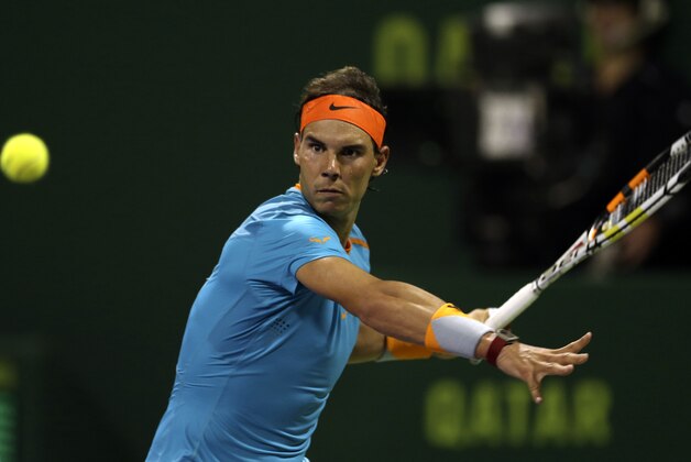 Spaniard Rafael Nadal returns the ball to Michael Berrer of Germany during the Qatar ATP Open Tennis tournament in Doha, Qatar, Tuesday, Jan. 6, 2015. (AP Photo/Osama Faisal)